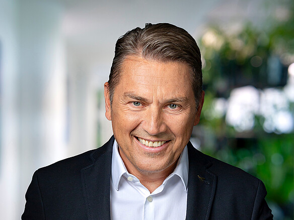 Christian Spannbauer - Vice President Aviation Commerce LHIND Mann mit kurzen dunklen Haaren, blauen Augen, schwarzem Jackett und weißem Hemd