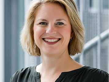 Friendly smiling woman with medium-length blonde hair and a black blouse