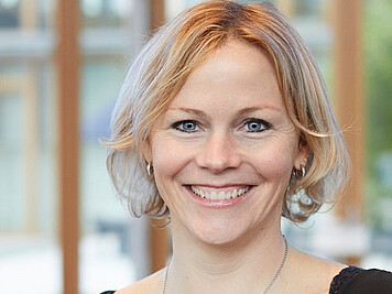 Friendly smiling woman with medium-length blonde hair and blue eyes